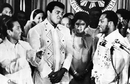Ferdinand Marcos aplaude a Joe Frazier mientras el boxeador habla de su rival, Muhammad Ali. Ambos visitaron al presidente filipino en el palacio de Malacañang, en Manila, el 18 de septiembre de 1975, días antes de la pelea. Entre ellos aparece Imelda Marcos. (Foto: Jess Tan/AP)