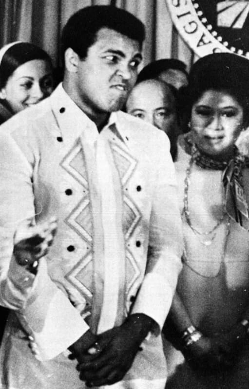 Ferdinand Marcos aplaude a Joe Frazier mientras el boxeador habla de su rival, Muhammad Ali. Ambos visitaron al presidente filipino en el palacio de Malacañang, en Manila, el 18 de septiembre de 1975, días antes de la pelea. Entre ellos aparece Imelda Marcos. (Foto: Jess Tan/AP)