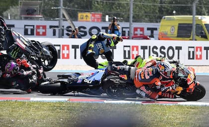 Fermín Aldeguer (Gresini Racing) vuela y Pedro Acosta (KTM) escapa del accidente de la primera Curva; en el piso, Jorge Martín (Aprilia), quien desató el caos y atropelló a cuatro rivales