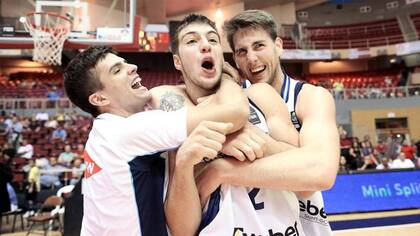 Fermín Thygesen (izquierda) y Ariel Ramos (derecha), abrazan a Máximo Fjellerup, el hombre que definió el partido en favor de Bahía