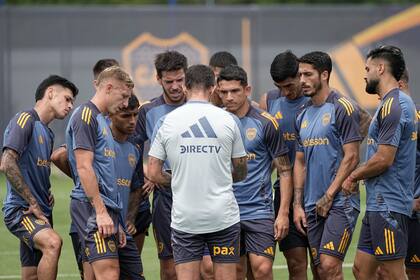 Fernando Gago da indicaciones en la previa a un entrenamiento de Boca; lo escuchan Aguirre, Barinaga, Martegani, Lautaro Blanco, Figal y Milton Giménez, entre otros