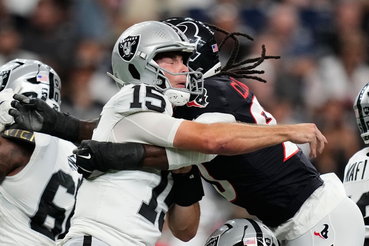 Fernando Mendoza, quarterback de los Raiders de Las Vegas, es golpeado por Jadeveon Clowney, ala def