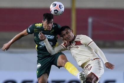 Fernando Meza lucha en lo alto con Alex Valera en el 1-1 entre Universitario y Defensa y Justicia en Lima, por la Copa Libertadores.