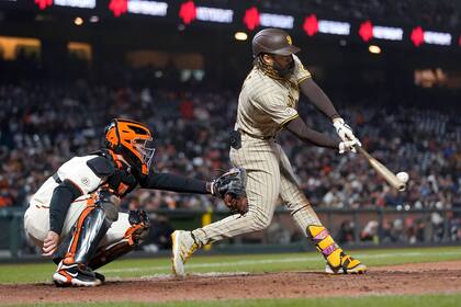 Fernando Tatis Jr., de los Padres de San Diego, conecta un sencillo ante el catcher de los Gigantes de San Francisco, Buster Posey, en el sexto inning del juego de la MLB que enfrentó a ambos equipos en San Francisco, el 15 de septiembre de 2021. (AP Foto/Jeff Chiu)