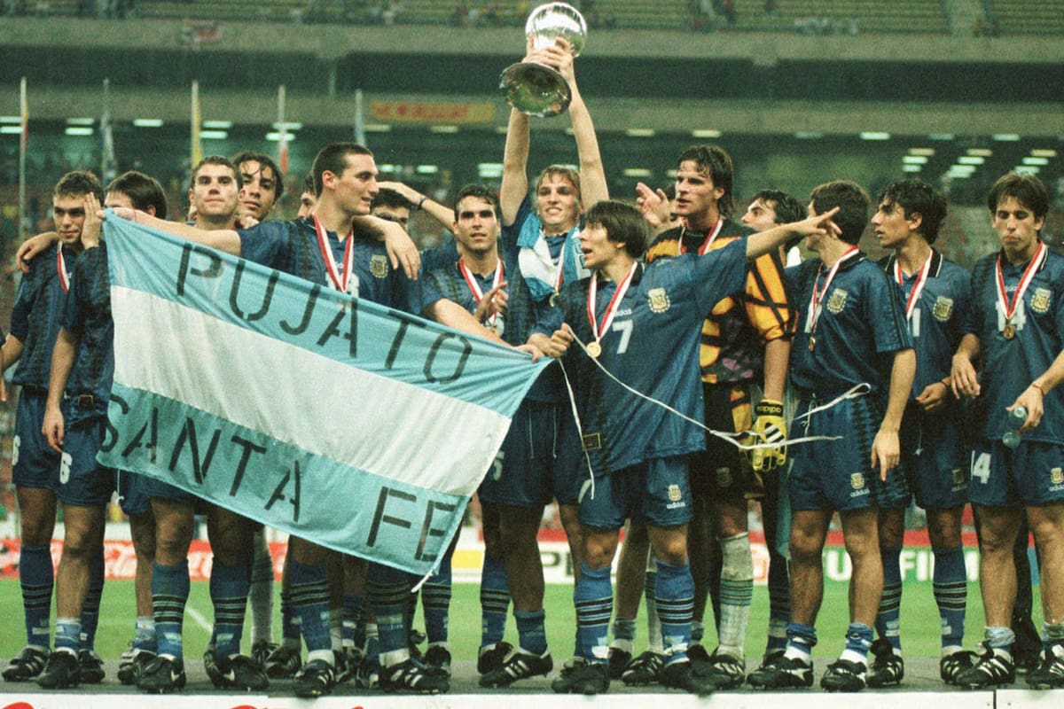 Festejo argentino tras vencer en la final de Malasia 1997 a Uruguay; Esteban Cambiasso levanta el trofeo de campeón mundial y Lionel Scaloni lleva la bandera de su Pujato natal
