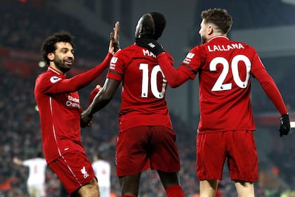 Festejo del líder: Salah, Mané y Lallana celebran el apretado triunfo de Liverpool.