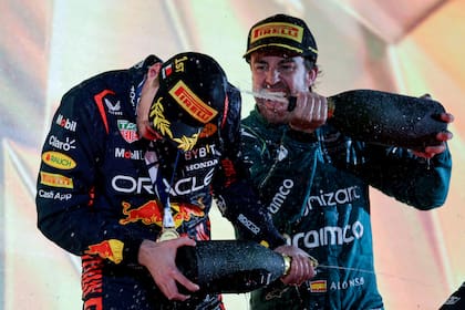 Festejos en el podio de Bahrein, con Fernando Alonso (Aston Martin) empapando a Max Verstappen (Red Bull)
