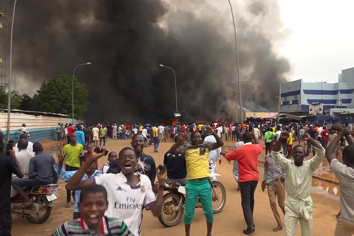 Festejos por el golpe de Estado en Níger, con la sede del gobierno ardiendo de fondo