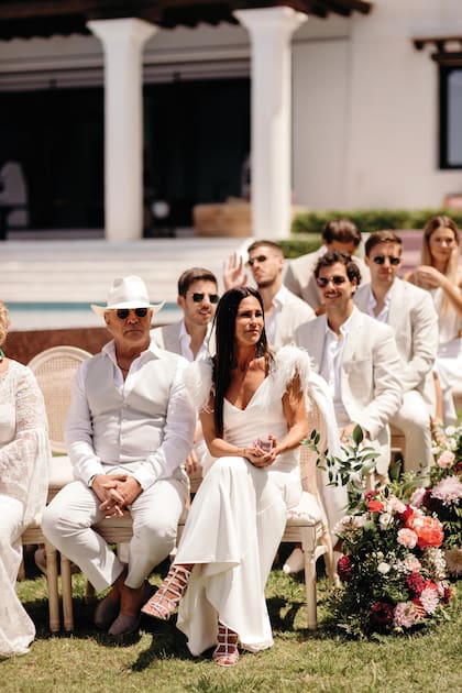 Fiel al dress code establecido para el gran día (total white), la mamá
del novio, Carolina Baldini, impactó con un vestido con plumas en los hombros
que complementó con sandalias plateadas.