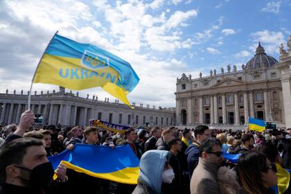 Fieles muestran banderas ucranianas durante la oración del mediodía del papa Francisco en la Plaza de San Pedro, en el Vaticano, el domingo 27 de febrero de 2022. (Foto AP/Gregorio Borgia)