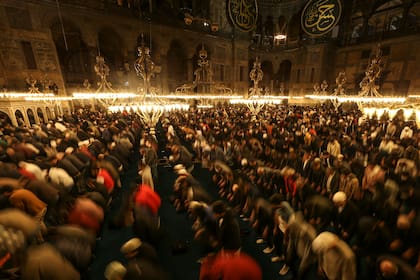 Fieles musulmanes durante el rezo nocturno del tarawih, que se realiza en la víspera del primer día del mes sagrado del islam, el ramadán, en la mezquita de Hagia Sophia, en Estambul, Turquía, el 1 de abril de 2022. (AP Foto/Emrah Gurel)