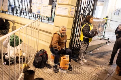 Fieles se acercan a una imagen de San Cayetano para dejar sus pedidos de trabajo, salud y alimento