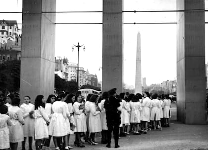 Fila de estudiantes que se retiran de la Feria. Al fondo, el obelisco. A la izquierda, el chalet de Muebles Díaz.