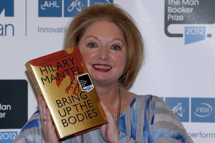 FILE - Hilary Mantel, winner of the Man Booker Prize for Fiction, poses with a copy of her book 'Bring up the Bodies', shortly after the award ceremony in central London, on Oct. 16, 2012. Mantel, the Booker Prize-winning author of the acclaimed √¢ˇÊ¨‡ÖìWolf Hall√¢ˇÊ¨ˇÊ¨ saga, has died, publisher HarperCollins said Friday Sept. 23, 2022. She was 70. (AP Photo/Lefteris Pitarakis, File)