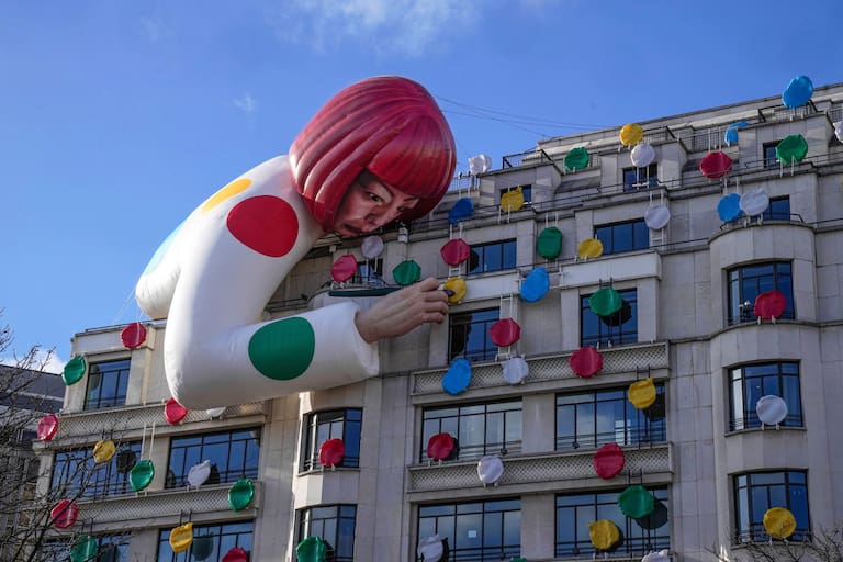 FILE - The installation of Japanese artist Yayoi Kusama, peering over the Louis Vuitton flagship store is pictured at the Champs Elysees avenue in Paris, Sunday, Jan. 15, 2023. (AP Photo/Michel Euler, File)