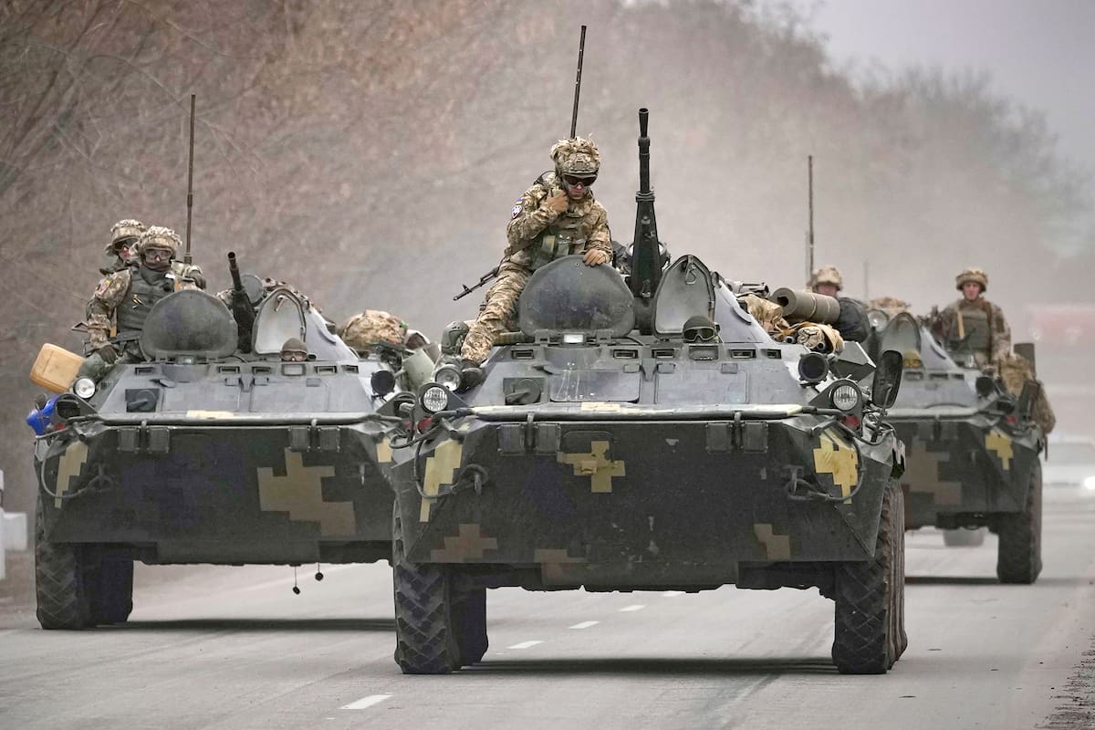 FILE - Ukrainian servicemen sit atop armored personnel carriers driving on a road in the Donetsk region, eastern Ukraine, Thursday, Feb. 24, 2022. (AP Photo/Vadim Ghirda, File)
