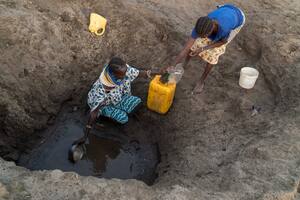 FILE — Two women collect water from a hole in a dry river bed in Turkana County, Kenya during a drought on Feb. 6, 2018. Africa is heating up much faster than the rest of the world. (Joao Silva/The New York Times)