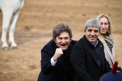 (FILES) Argentina's President Javier Milei (L), his sister, Secretary General of the Presidency Karina Milei and Economy Minister Luis Caputo arrive for the Argentine Rural Society's expo in Buenos Aires on July 26, 2025. Argentina's budget-slashing President Javier Milei on August 4, 2025, vetoed a law approved by parliament to increase pensions for the elderly and the disabled, arguing it undermined his attempts to balance the budget. (Photo by AFP)