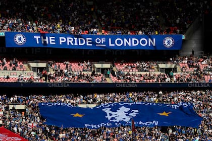 (FILES) In this file photo taken on April 17, 2022, Chelsea supporters display a large flag as they build the atmosphere ahead of the English FA Cup semi-final football match between Chelsea and Crystal Palace at Wembley Stadium in north west London. - Chelsea FC said on May 6, 2022 a group led by Los Angeles Dodgers co-owner Todd Boehly would acquire the London club after agreeing terms in a deal worth £4.25 billion (USD 5.2 billion). (Photo by Glyn KIRK / AFP) / NOT FOR MARKETING OR ADVERTISING USE / RESTRICTED TO EDITORIAL USE