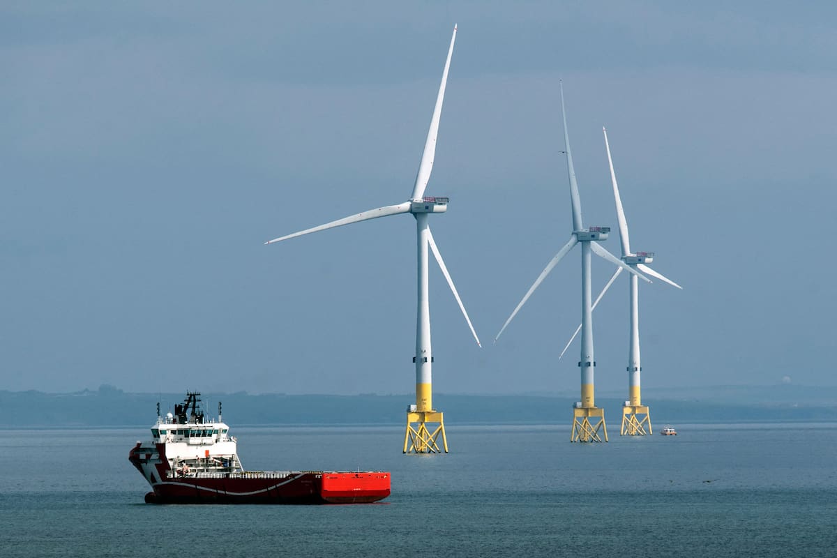 (FILES) In this file photo taken on April 29, 2022 a ferry navigates past wind turbines off the coast of Aberdeen in the North East of Scotland. - In Aberdeen, northeast Scotland, offshore wind turbines, the extension to the city's port, and hydrogen buses are clear evidence of the move to green energy. But old habits die hard in the Granite City, which was built on the back of profits of oil and gas piped from the often turbulent waters off its shores. (Photo by Andy Buchanan / AFP)