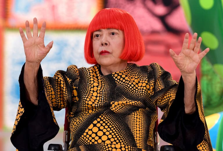 (FILES) Japanese artist Yayoi Kusama waves at a photo session during a press preview of her exhibition titled "My Eternal Soul" at the National Art Center in Tokyo on February 21, 2017. Japanese avant-garde artist Yayoi Kusama, known as the "polka dot queen", has died aged 97, a statement from her company said on August 27, 2026. (Photo by TOSHIFUMI KITAMURA / AFP) / RESTRICTED TO EDITORIAL USE, MANDATORY CREDIT OF THE ARTIST, "YAYOI KUSAMA" TO ILLUSTRATE THE EVENT AS SPECIFIED IN THE CAPTION.