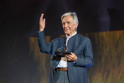 Film Director Costa-Gavras gestures after receiving the Pardo alla carriera Award at the Piazza Grande at the 75th Locarno International Film Festival in Locarno, Switzerland, Thursday, Aug. 11, 2022. The Festival del film Locarno runs from 3 to 13 August 2022. (Urs Flueeler, Keystone via AP)