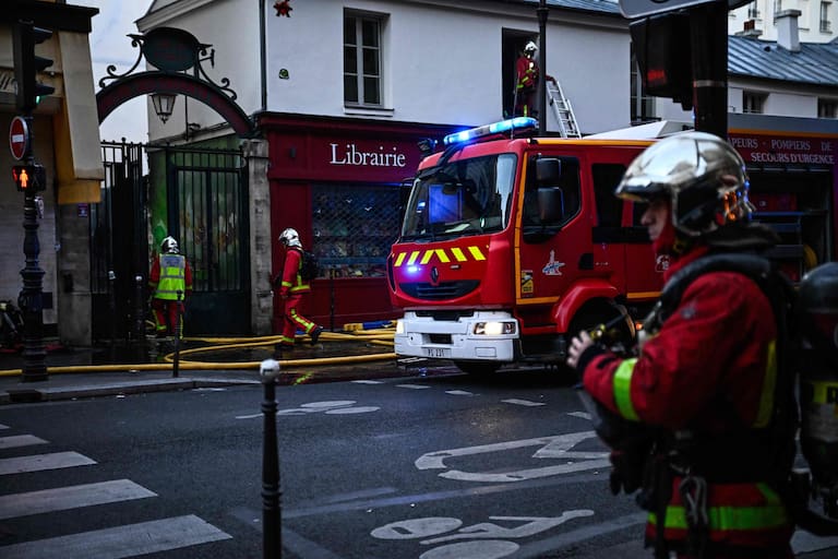Firefighters work to extinguish a fire at «Le marche des Enfants Rouges» (Red Children market) center of Paris on October 12, 2026. (Photo by JULIEN DE ROSA / AFP)