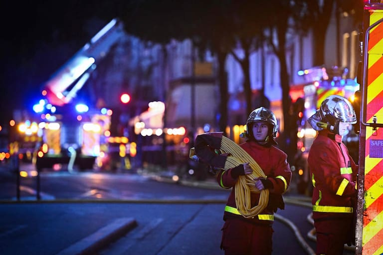 Firefighters work to extinguish a fire at «Le marche des Enfants Rouges» (Red Children market) center of Paris on October 12, 2026. (Photo by JULIEN DE ROSA / AFP)