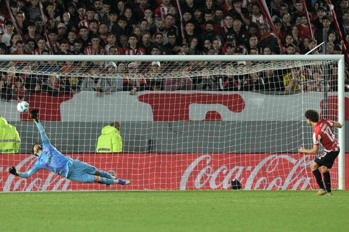 Flamengo's Argentine goalkeeper #01 Agustin Rossi makes a save past Estudiantes's defender #13 Gaston Benedetti during the penalty shootout of the Copa Libertadores quarterfinal second leg football match between Argentina's Estudiantes de La Plata and Brazil's Flamengo at the Jorge Luis Hirschi Stadium in La Plata, Buenos Aires province, Argentina on September 25, 2025. (Photo by Juan MABROMATA / AFP)