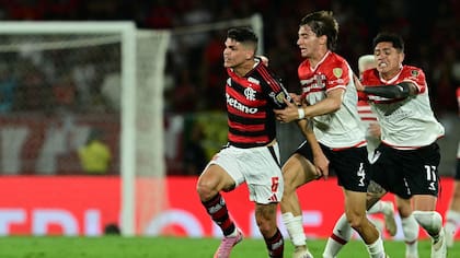 Flamengo's defender #06 Ayrton Lucas and Estudiantes's defender #04 Roman Gomez fight for the ball during the Copa Libertadores quarterfinal first leg football match between Brazil's Flamengo and Argentina's Estudiantes de La Plata at the Maracana Stadium in Rio de Janeiro, Brazil on September 18, 2025. (Photo by Pablo PORCIUNCULA / AFP)