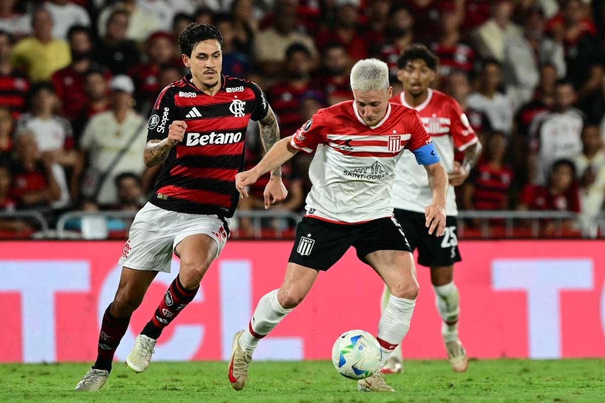 Flamengo's Uruguayan midfielder #10 Giorgian de Arrascaeta and Estudiantes' midfielder #05 Santiago Ascacibar fight for the ball during the Copa Libertadores quarterfinal first leg football match between Brazil's Flamengo and Argentina's Estudiantes de La Plata at the Maracana Stadium in Rio de Janeiro, Brazil on September 18, 2025. (Photo by Pablo PORCIUNCULA / AFP)