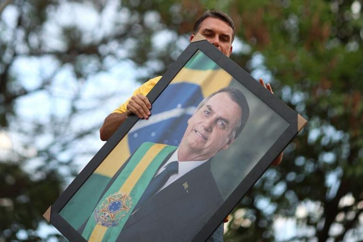 Flavio Bolsonaro sostiene un retrato de su padre