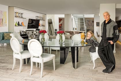 Flavio posa junto a Dionisio en el amplio living-comedor de su casa, que tiene hasta una parrilla. La réplica de la Copa del Mundo que vemos sobre la mesa está armada con piezas de Lego