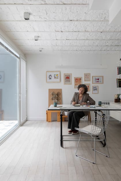 Flor en su escritorio, con sillas ‘Bertoia’ (Manifesto) y la vajilla de cerámica que hizo ella misma. Tablero de dibujo (Pizzini)
