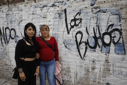 Florencia Generoso, referente del Movimiento Evita, y Griselda Cabrera, una de las militantes que denunciaron un ataque mientras hacían pintadas, frente al paredón en el que sucedieron los hechos