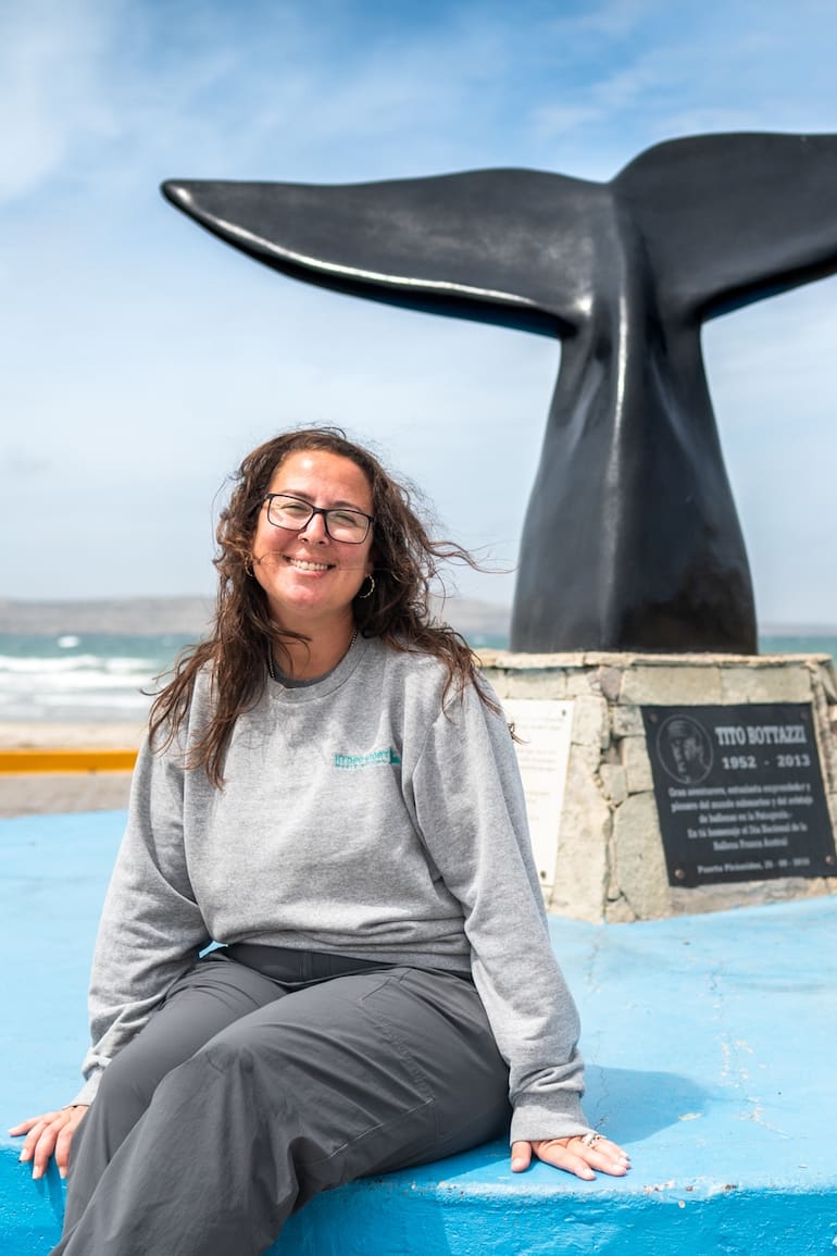 Florencia van Gelderen con el monumento que recuerda a su papá y a otros pioneros de la zona