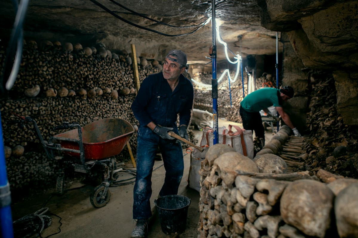 Florent Bastaroli trabaja en la restauración de las catacumbas de París. Durante siglos, los huesos de seis millones de parisinos fueron arrojados allí. Los restauradoras intentan preservar y modernizar los túneles sin alterar el ambiente. (Dmitry Kostyukov/The New York Times)