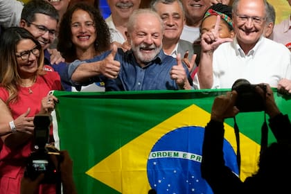 Former Brazilian President Luiz Inacio Lula da Silva celebrates with his wife Rosangela Silva, left, and running mate Geraldo Alckmin, right, after the electoral authority said that he defeated incumbent Jair Bolsonaro to become the country's next president, in Sao Paulo, Brazil, Sunday, Oct. 30, 2022. (AP Photo/Andre Penner)