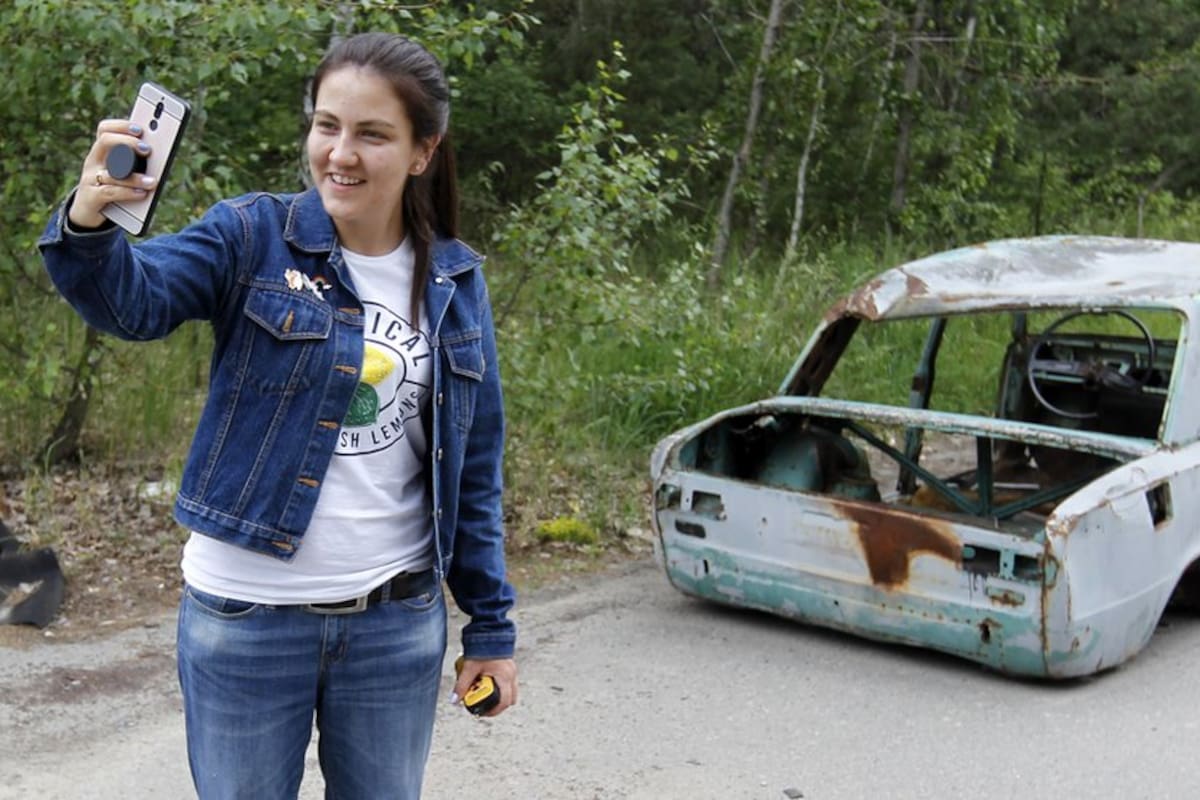Foto de archivo: una turista posa en la zona de exclusión de Chernóbil en la ciudad abandonada de Pripyat este mes.