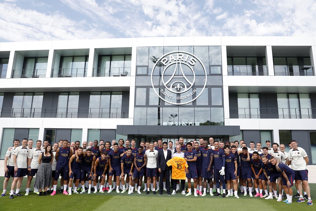 Foto de familia: el plantel de Paris Saint-Germain en la inauguración del centro de entrenamiento del club, con al presidente Nasser Al-Khelaïfi en el centro y Kylian Mbappé en un costado, a la izquierda.