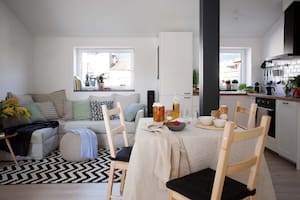 Foto de un ambiente que integra cocina, living y comedor con heladera escondida dentro de un placard.
