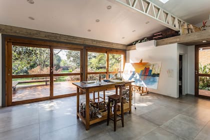 El atelier cuenta con un acceso independiente en el lado sur. La puerta simple revela un pasillo entre él y la casa principal.