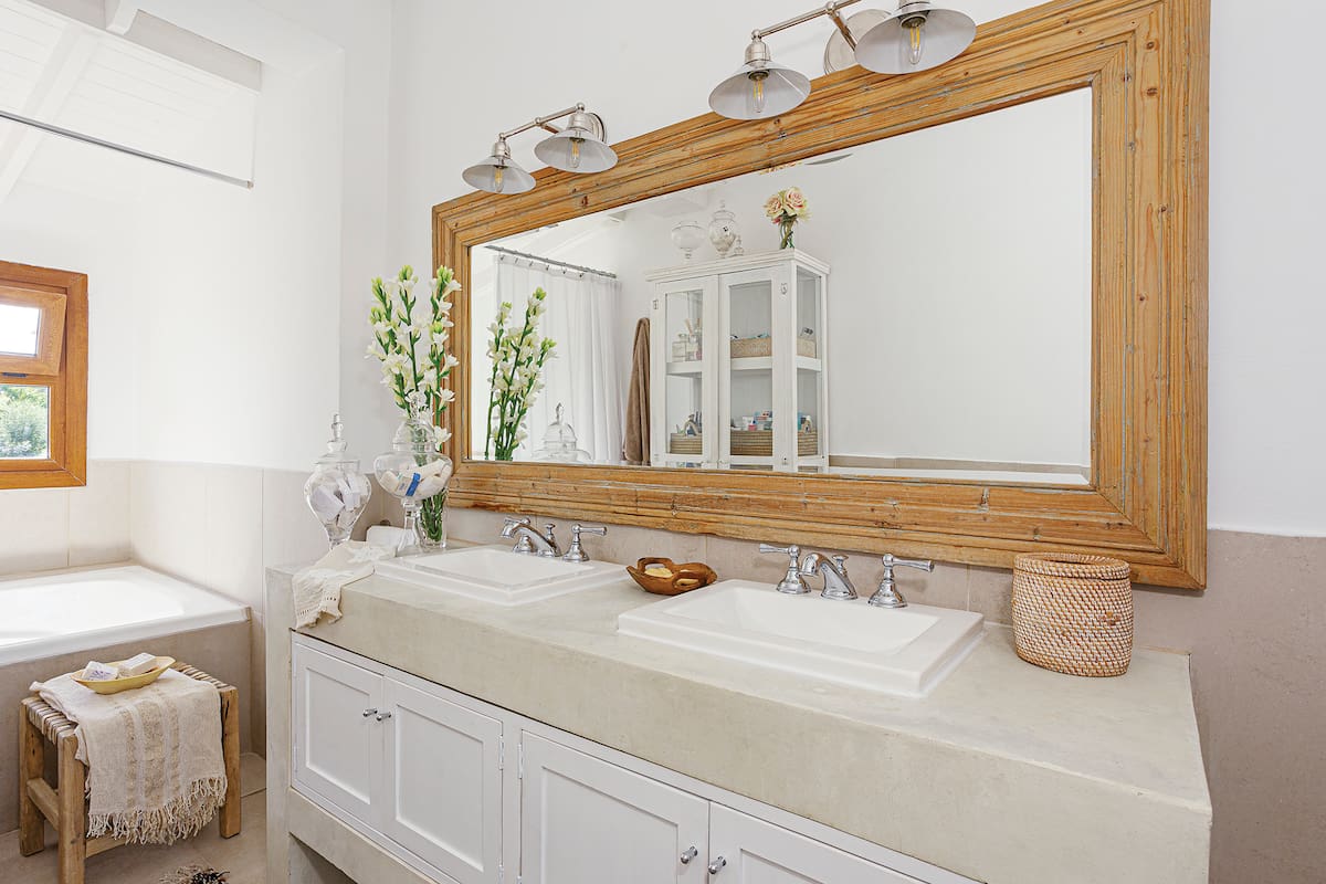 Foto de un baño con aparador, mueble con mesada de cemento alisado y apliques.