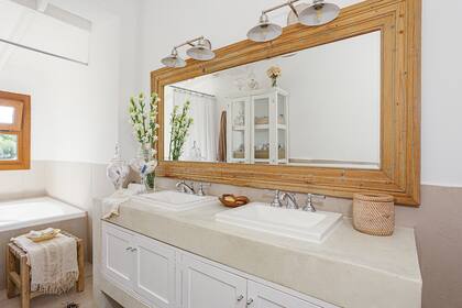 Foto de un baño con aparador, mueble con mesada de cemento alisado y apliques.