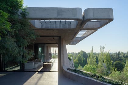 Cuatro terrazas prolongan la casa hacia el paisaje, acompañadas por canteros en los que crece con fuerza la vegetación.