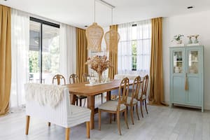 Foto de un comedor con cortinas traslúcidas enmarcadas por un cantonnier de terciopelo arena.
