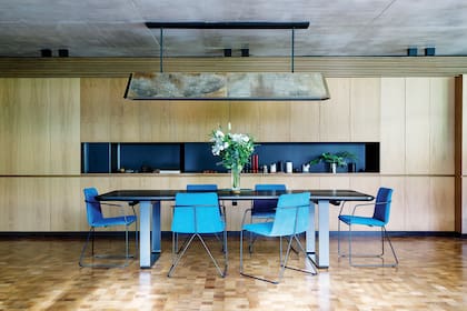 Mesa de comedor (Daf Casa). Sillas ‘Horqueta’ (Federico Churba). Lámpara revestida en cuero (Duveen-Tolz Estudio y Lerner-Raffo Arquitectos). Flores (Regiacasa).