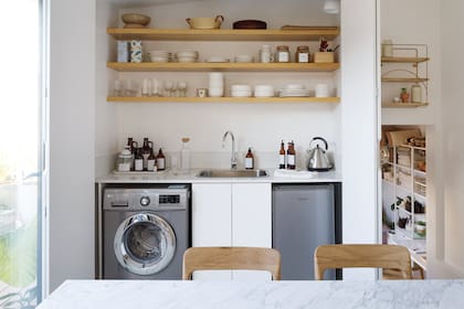 Mueble bajomesada de MDF con mesada de Silestone ‘Blanco Puro’. Bacha (Johnson Acero), grifería (FV). Heladera (Philco),