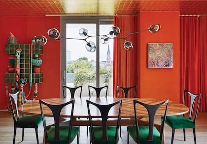 Mesa de nogal (Kerylos Intérieurs), sillas de Guglielmo Ulrich tapizadas con terciopelo y lámpara de la gran Lindsey Adelman. Las cortinas se hicieron con género de Hermès en su naranja característico.
