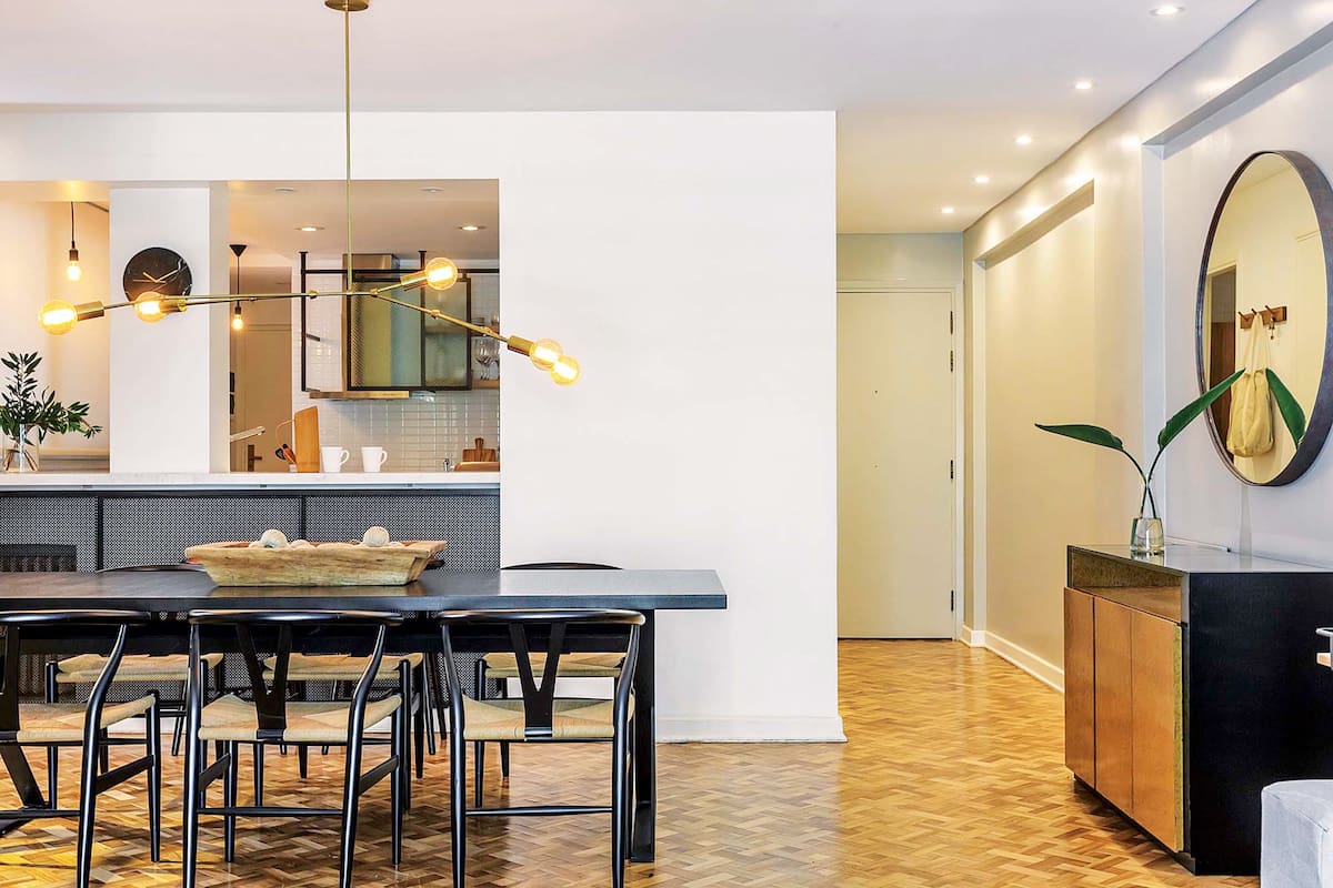 Foto de un comedor con mesa de madera teñida de color oscuro y llamativa lámpara de Paul French Gallery.